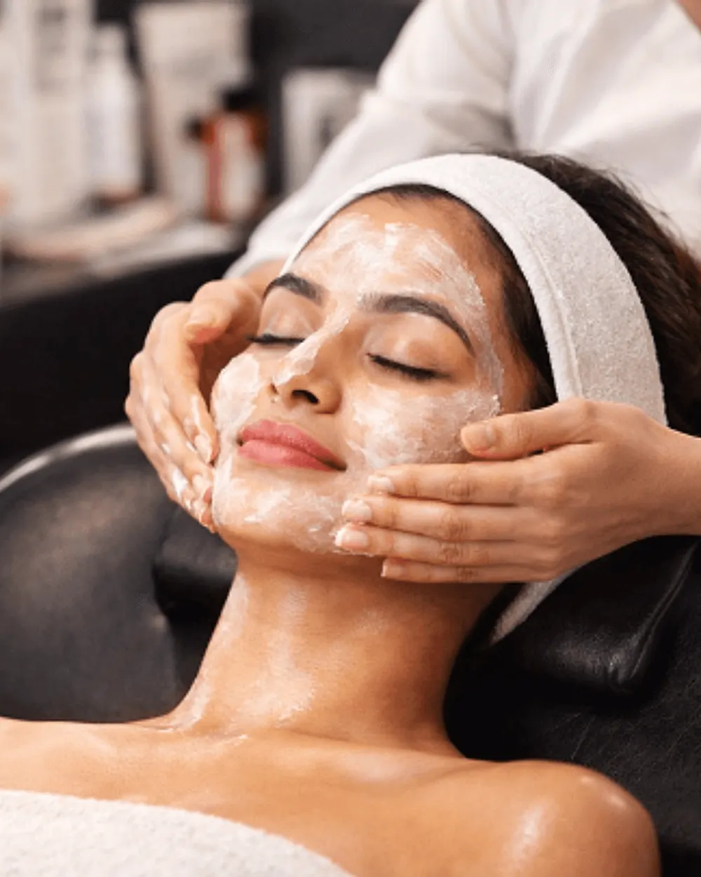 A woman receiving a relaxing facial skincare treatment in a salon